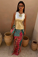 Pastel Morocco Dorris Skirt in an abstract multi print, styled with a metallic gold vest and clay pot backdrop.