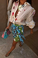 Morocco Mini Wrap Skirt with green and blue sun face prints, featuring a wrap tie fastening for a multi-wear look.