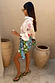 Morocco Mini Wrap Skirt featuring a multi-colour sun print and side tie fastening, paired with a patterned white shirt.