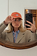 Multi Stripe Cap in tan brown and red cotton with baby blue NFD embroidery, worn by a model in a mirror selfie.