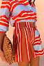 Thumbnail for Multi Stripe Tate Shorts with a high wide waistband and vertical stripes, styled with a spotted animal print clutch.