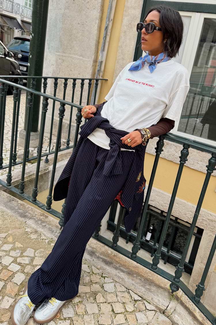 Navy Pinstripe Arden Trousers styled with a white graphic tee and matching blazer for a smart-casual London look.