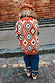 NFD Kids Diamond Bomber in rust orange with olive and red diamond patterns, worn by a child on a cobbled street.