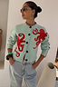 Thumbnail for Octopus Cardigan in blue knit with red motifs designed in-house and blanket stitching, styled with denim jeans.