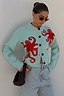 Thumbnail for Blue Octopus Cardigan with red embroidered motifs and blanket stitch detail, styled with light wash jeans.