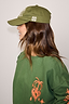 Thumbnail for Olive Amara Cap in green cotton with white embroidery, styled with a matching green graphic sweatshirt.