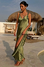 Thumbnail for Olive Sofia Dress in olive green satin with tie-knot shoulders and a side split, styled in a holiday resort setting.