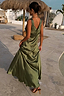 Olive Sofia Dress in satin featuring a bias-cut drape, V-back, and tie-shoulder detail in a vacation setting.
