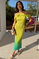 Lime Ombre Plisse Claudia Dress with cold shoulder frills and gold flecks in a vacation setting.