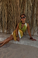 Green Ombre Deia Dress with earthy tones and raffia trim, styled in a sunny vacation setting.