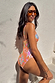 Orange Dreamer Scoop Swimsuit with a sun and palm print, shown in a side profile and styled with sunglasses.