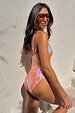 Orange Dreamer Scoop Swimsuit with a sun and palm print, shown in a side profile and styled with sunglasses.