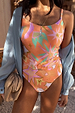 Orange Dreamer Scoop Swimsuit with iconic palm and sun prints and a statement buckle belt, layered with a blue shirt.