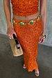 Orange Sequin Dorris Skirt in burnt orange, styled with a matching top and a green stone belt.