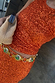 Thumbnail for Orange Sequin Tank Top and matching skirt with shimmering sequins, styled with a woven clutch and green jewelled belt.