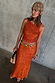 Orange Sequin Tank Top styled with a matching sequin skirt and a tan crochet beaded headpiece.