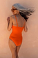 Orange Sun Bandeau Swimsuit with adjustable straps, shown from the back on a model for a beach vacation.