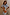 Thumbnail for Orange Acetate Visor Sunglasses with 70s-inspired tinted lenses, worn by a smiling model in a blue floral dress.