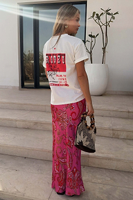 Pink Paisley Dorris Skirt with a bold print, styled with a white graphic t-shirt on stone steps.