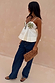 Ivory Palm Nara Top in cotton with green palm motifs, styled with blue jeans and a leopard print clutch bag.