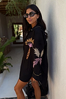 Black Palm Embroidered Shirt with pink and yellow palm motifs on the sleeves, styled in a vacation setting.