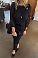 Black Plisse Perrie Dress featuring sheer sleeves and balloon cuffs, styled with a matching clutch for an evening look.