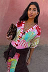 Pink Dallas Cardigan featuring abstract cowboy motifs and striped trim, styled with a leopard print clutch.