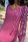 Pink Harmony Dress featuring a gold jacquard animal print, tassel neckline and long sleeves.