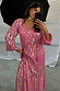 Pink Jacquard Harmony Dress featuring gold animal print, tassel neckline and long sleeves in a mirror selfie.