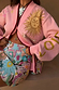 Pink Mystical Cardigan with gold jacquard sun motifs and burgundy trims, paired with a colourful beaded star skirt.