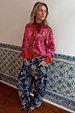 Pink Paisley Oslo Cardigan with red ribbed trims and intricate print, styled with blue paisley jeans and leopard heels.