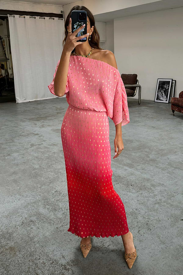 Pink and red ombre Tilly Dress in gold shimmer plisse, styled as a one-shoulder midi dress in a mirror selfie.