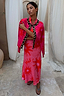 Thumbnail for Boxy Pink Soleil knit cardigan with red sun motifs and leopard trim, worn over a matching maxi dress.