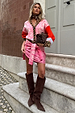 Pink paisley and leopard print Splice Bandana Cardigan with red accents, styled on a model on stone steps.
