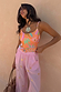 Pink Elissa Trousers with gold foil sun motifs and a wide-leg fit, paired with a patterned top and sun necklace.