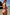 Thumbnail for Pink Fruit Stamps Swimsuit with Mediterranean fruit prints and ruched side ties, worn by a woman at the beach.