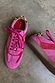 Pink and red trainers with a soft suede finish, leopard print heel tab and matching pink laces.