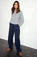 Navy Pinstripe Arden Trousers in a wide-leg fit, styled with a grey knitted jumper and leopard print shoes.