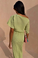 Pistachio Tilly Dress in green plisse with gold flecks, featuring an off-the-shoulder neckline and lettuce hems.
