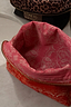 Thumbnail for Red Bandana Reversible Make Up Bag featuring a pink paisley print interior and gold-tone zip on a marble surface.