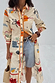 Cream Poema Shirt Dress with bright motifs and orange lettuce trim, styled as a multi-wear layer over shorts.