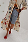Cream Poema Shirt Dress with colourful island motifs and orange lettuce trim, styled open over denim shorts.