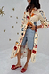 Poema Shirt Dress in cream with bright motifs, styled as a multi-wear layer over denim shorts.