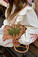 Cream Pollenca Mini Dress in cotton with red embroidery and ruffles, styled with a woven palm tree bag.