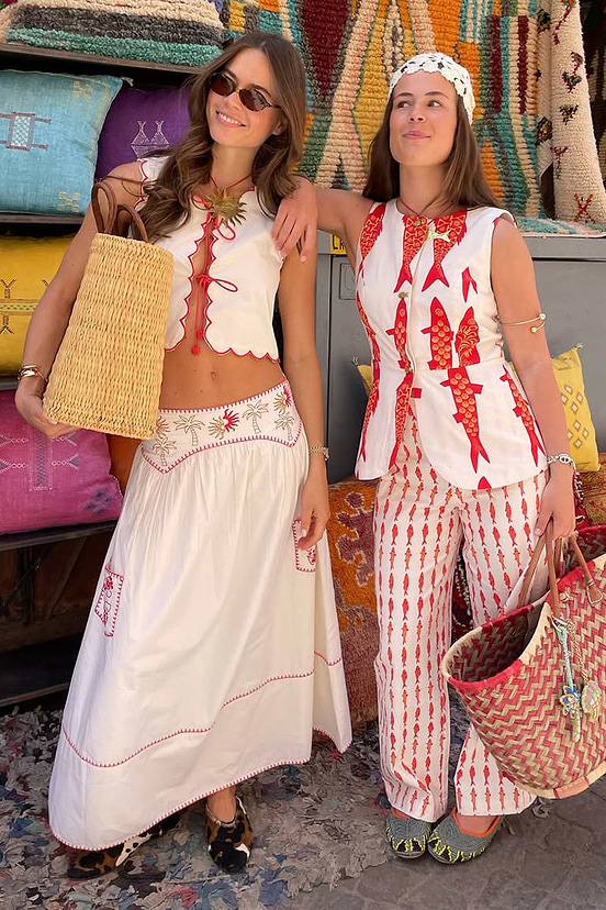 Cream and Red Pollenca Skirt with sun and palm embroidery, styled with a matching top and a woven straw bag.