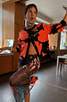 Soft-touch Black Poppy Cardigan with a red poppy print and wide sleeves, styled over a matching mesh dress.