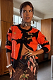 Black Poppy Cardigan with an iconic red poppy print and wide sleeves, styled over a patterned mesh dress.