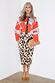 Blue Poppy Cardigan with a red poppy print and leopard trim, styled with a leopard midi skirt on a silver-haired model.