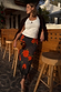 Black Poppy Midi Maeva Skirt with an iconic red floral print and lace trim, styled with a white tank and suede jacket.