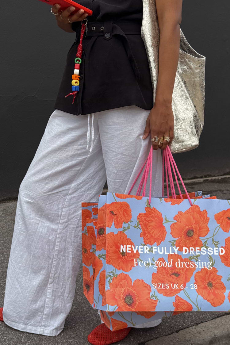 Blue Poppy Gift Bag with orange floral print and pink handles, featuring the NFD Feel good dressing slogan.